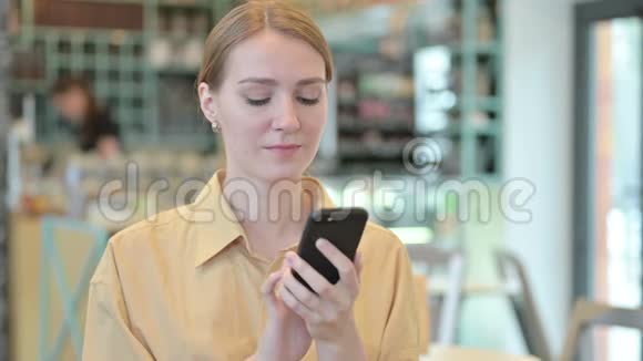 女青年在智能手机上讲话的画像视频的预览图