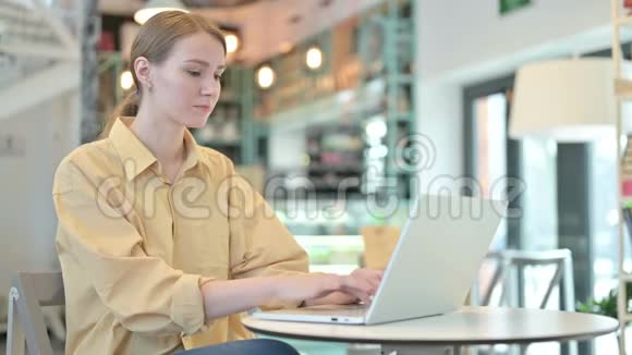 年轻女子在咖啡厅手提电脑庆祝成功视频的预览图