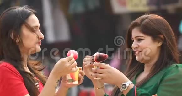 两个女人吃着蘸着糖浆的调味冰果酱视频的预览图