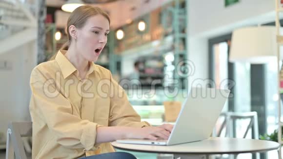 年轻女子因在咖啡厅的笔记本电脑上丢失而心烦意乱视频的预览图