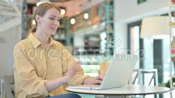 女青年在咖啡厅进行电脑聊天视频的预览图