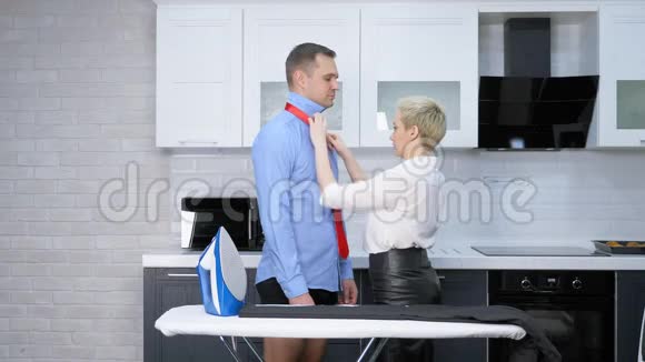 女人在家里在厨房系男人领带生活方式视频的预览图