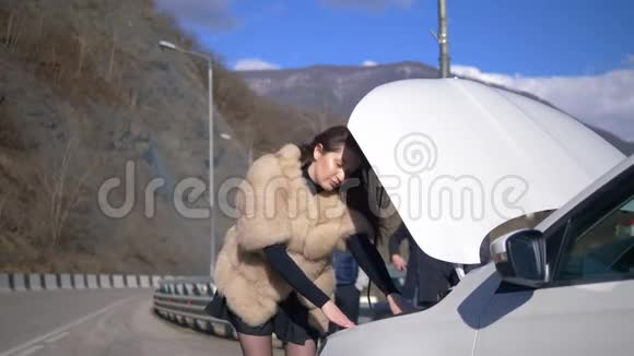 女孩看着车的保险杠男人用电话把它移开视频的预览图