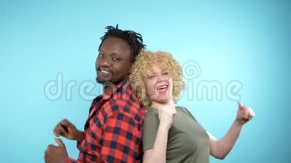非洲男人和白种人的非洲发型正在跳舞蓝色背景视频的预览图