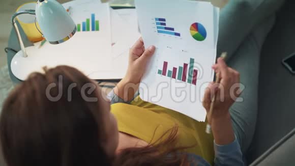 特写顶部的孕妇工作与图形图表在家里视频的预览图