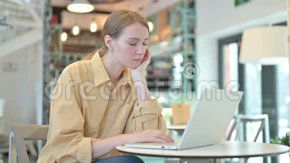 带手提电脑的年轻女子在咖啡厅打盹视频的预览图