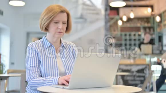 雅宁创意老女人在咖啡厅的笔记本电脑视频的预览图
