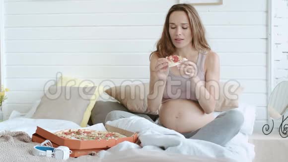 特写孕妇在家里用快餐放松妈妈在吃披萨视频的预览图