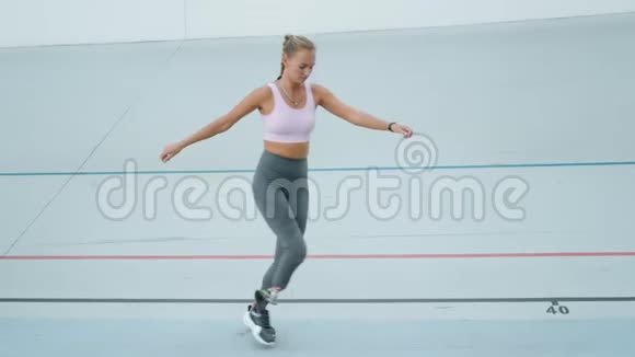 有假肢的运动员在跑道上侧跳体育场女子训练视频的预览图