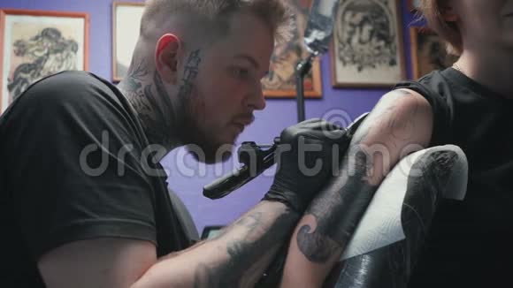 男子在画室为妇女做蛇黑纹身视频视频的预览图