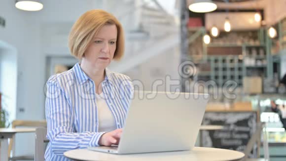 创意老女人在咖啡厅丢失笔记本电脑视频的预览图