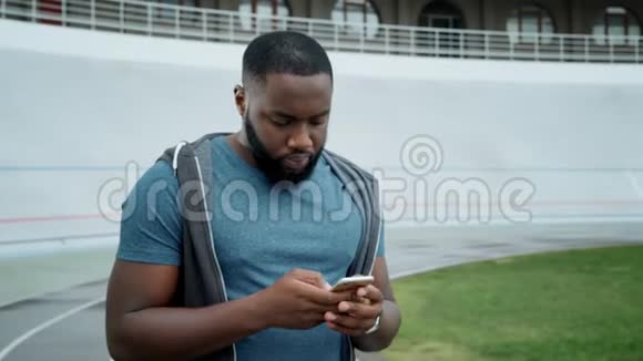 运动员在体育场使用智能手机运动员在智能手机上发短信视频的预览图