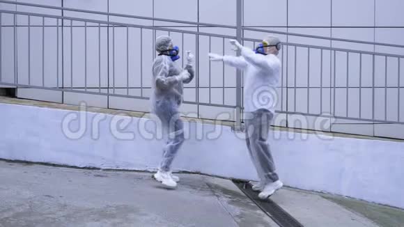 人们穿着防护服和呼吸器走过科技大楼视频的预览图