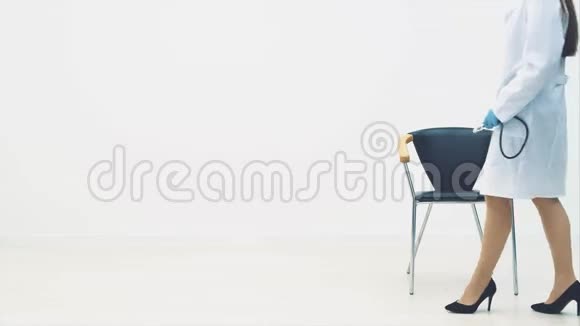 迷人的治疗师坐在椅子上摘下医疗面具微笑着指着科普空间视频的预览图