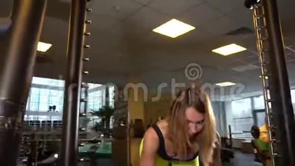 史密斯健身器上的成年女孩挤压黄色织物视频的预览图