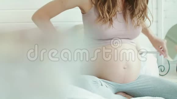 在光线充足的卧室里用丝锥测量孕妇的腹部视频的预览图