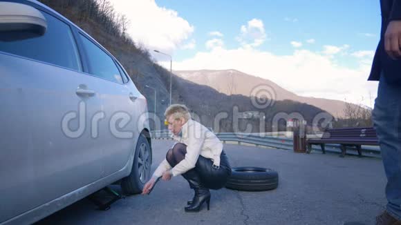 幽默女人换了一个汽车轮子一个人骑在电动滑板上经过视频的预览图