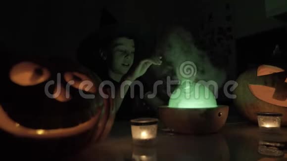 万圣节9岁男孩扮演巫师晚上桌子上有一盏神奇的灯和一个南瓜视频的预览图