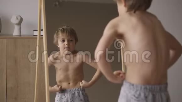 可爱的白种人男孩在镜子前展示肌肉运动力量医疗保健视频的预览图