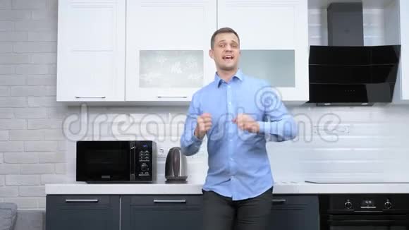 年轻的帅哥在厨房跳舞生活方式视频的预览图