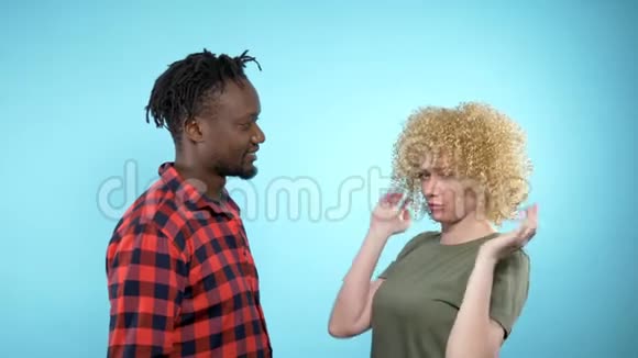 非洲男人和白人女人有非洲发型蓝色背景视频的预览图
