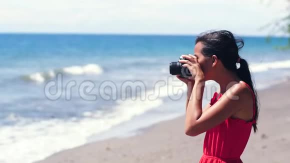 笨拙的女摄影师把单反相机丢在海滩上视频的预览图