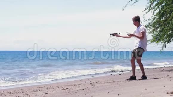 一个人试图在海滩上发射一架无人机但无人机掉了下来视频的预览图