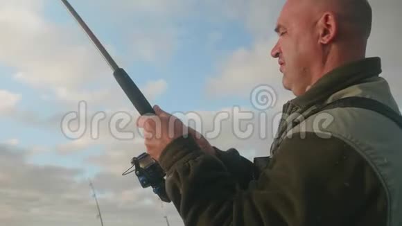 白渔夫把鱼拖在鱼竿上侧视视频的预览图