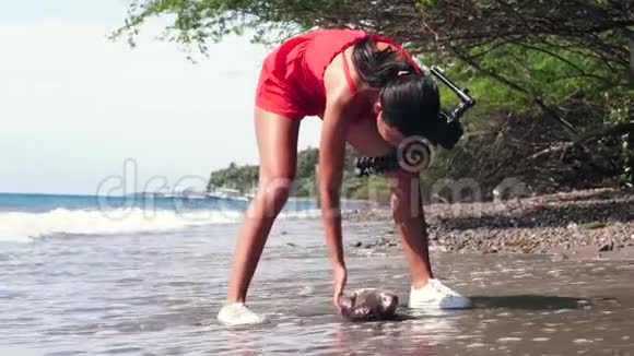 一个vlogger在为vlog拍摄故事时发现一条死鱼被冲到岸上视频的预览图