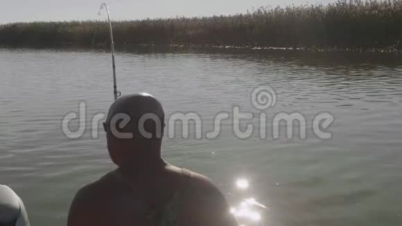 白种人渔夫把大鱼拉出来在后面点燃男人的爱好清晨钓鱼视频的预览图