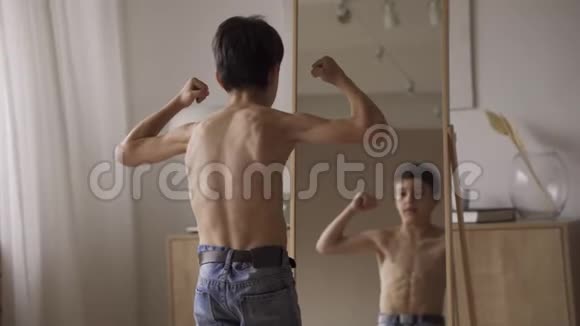 可爱的白种人男孩在镜子前展示肌肉运动力量医疗保健视频的预览图