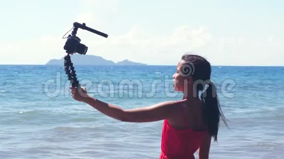 年轻的影响者在夏天在海滩上拍摄她的旅行日志视频的预览图
