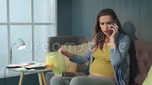 特写悲伤怀孕女商人在家办公室打电话视频的预览图