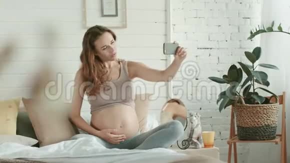 孕妇做自拍床肚皮妈妈打电话给怀孕的肚皮照视频的预览图