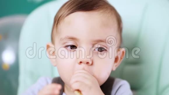 可爱的小男孩坐在椅子上吃饼干生日帅哥视频的预览图
