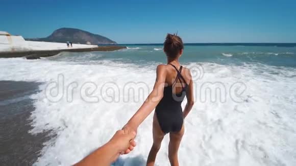 波夫第一人称观看幸福的夫妇牵手在挥动的海滩视频的预览图