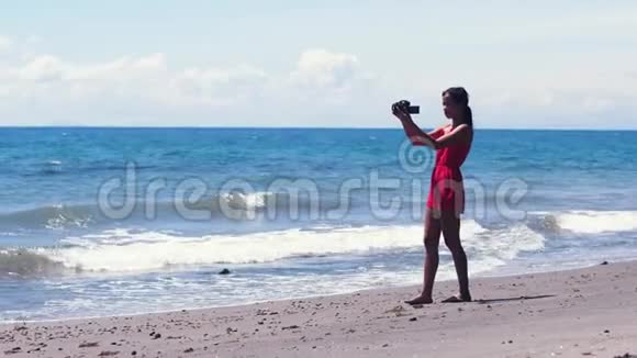 录像员女孩假期在海滩上的录像和拍照视频的预览图