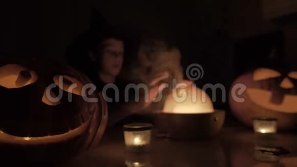 万圣节9岁男孩扮演巫师晚上桌子上有一盏神奇的灯和一个南瓜视频的预览图