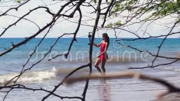 一位女性社交媒体影响者在海滩录制旅游博客视频的预览图
