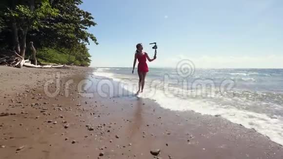 一位千禧一代的vlogger在海滩上散步并为社交媒体录制vlog视频的预览图