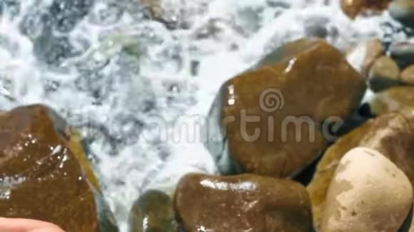 镜头左上角穿着泳装的苗条年轻女子盘腿坐在石头上视频的预览图