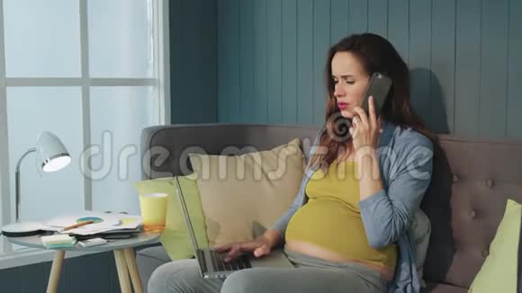 孕妇在家打电话贴身肚皮妈妈在工作笔记本电脑视频的预览图