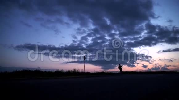 日落时分一个人在路上奔跑的剪影视频的预览图