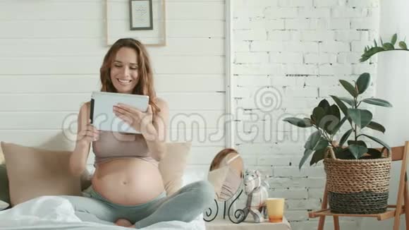 孕妇谈视频聊床准妈妈在家拿着平板电脑视频的预览图
