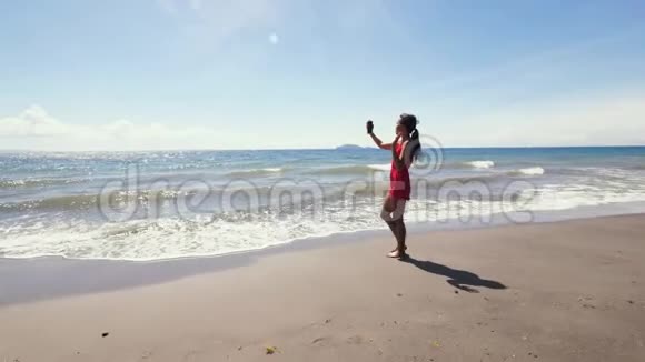 亚洲vlogger在夏天用智能手机在海滩上拍摄vlog视频的预览图