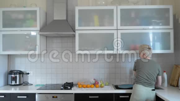 一个女人在家里的厨房里洗蔬菜和水果视频的预览图