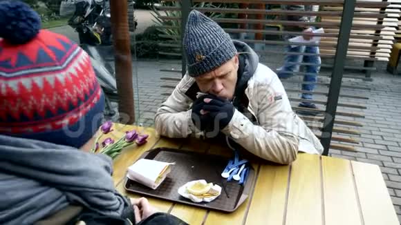 一对无家可归的夫妇一男一女在街头咖啡馆吃着桌上的剩菜视频的预览图