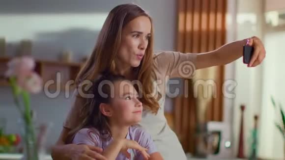 有魅力的女人在家里和女孩在智能手机上自拍视频的预览图