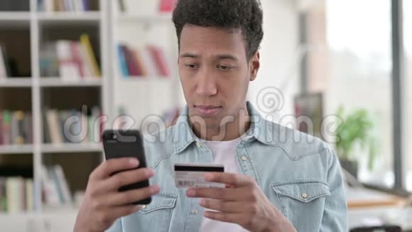 青年非洲男子网上购物智能手机网上支付视频的预览图