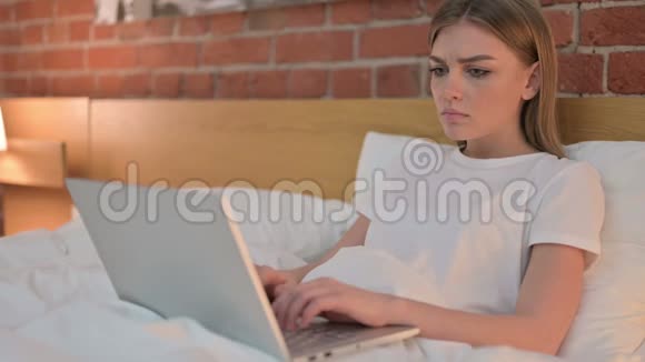 年轻女性对床上笔记本电脑丢失的反应视频的预览图